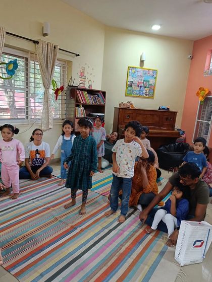 The children stand up to participate in an activity, showing the active and engaged nature of our community.