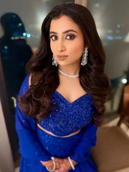 A dash of dazzle! I transformed this beauty into a showstopper with a bold and stunning makeup look, featuring smokey eyes and a nude lip, perfect for her royal blue outfit.
