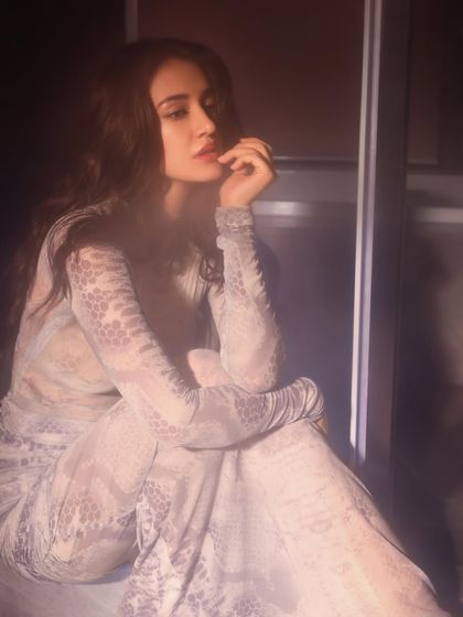 This moody, atmospheric shoot features Disha Patani in a sheer printed dress by Deme Love for the 'Kanguva' promotions. The styling here was about creating an alluring and mysterious vibe, playing with light and shadow.