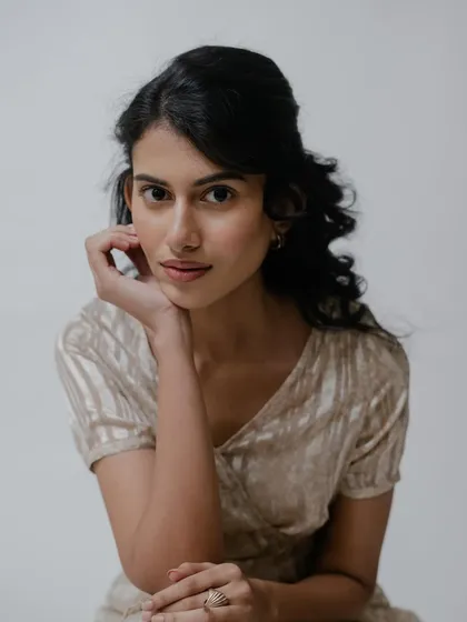 A classic portrait pose. The makeup is barely there, focusing on perfect skin and lightly defined features for a very natural and approachable look.