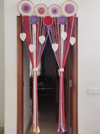 Our custom macrame dreamcatcher curtain tied back to create an elegant entrance. This piece is both a beautiful wall hanging and a functional door curtain.