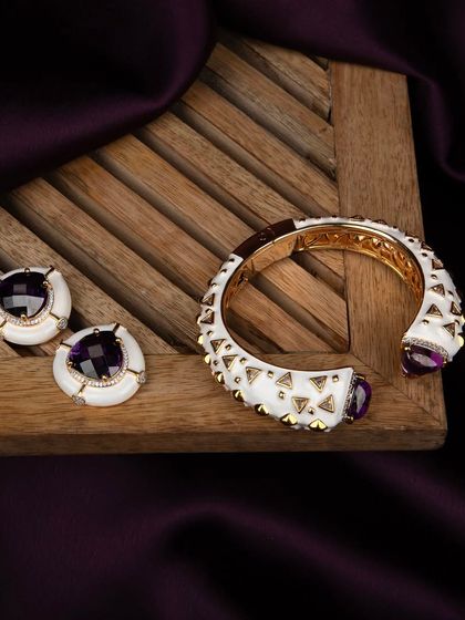 A top-down view of the white enamel jewellery set on a slatted wooden tray, providing a clean and modern presentation.