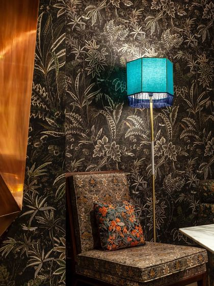 A comfortable chair in a cozy nook, perfect for an intimate conversation over cocktails. The mix of textures and patterns adds to the unique character of our space.