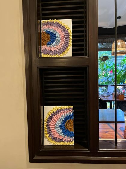 Two completed couple's art pieces displayed in a window. They look like beautiful, modern art installations.