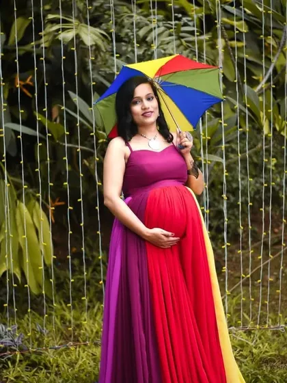 Capturing pure joy with this vibrant, rainbow-colored maternity gown. It's designed to be comfortable while beautifully highlighting the baby bump for a fun and colorful photoshoot.