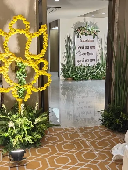 A simple yet elegant entrance I designed for a spiritual gathering. A sign with sacred mantras is framed by lush greenery and white flowers, with a beautiful marigold Om symbol to welcome guests with blessings.