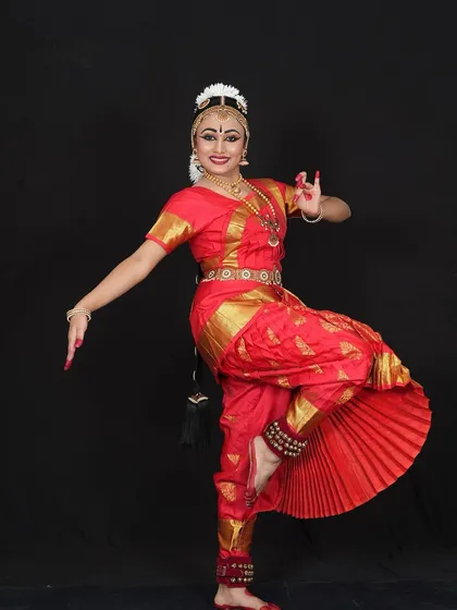 Aditri Rawat during her Arangetram photoshoot. The classic red and gold costume is a timeless choice for a Bharatanatyam debut, radiating energy and tradition.