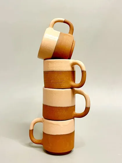 My handmade mugs are crafted for the simple joy of daily rituals. This stack of two-toned terracotta mugs showcases a minimalist design, combining earthy textures with a smooth glaze for a comfortable and beautiful sipping experience.