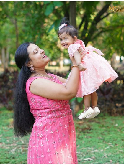 Pure happiness captured in a single frame. A mother lovingly lifts her daughter, and the genuine joy on both their faces is what makes family photography so special.