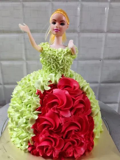 A vibrant doll cake with a green and red buttercream dress. I can customize the colors to match your party's theme.