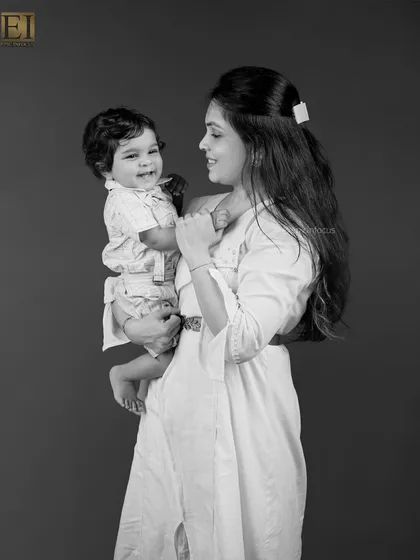 A mother gazes lovingly at her smiling baby. These black and white portraits emphasize emotion and connection, creating a powerful and intimate image.