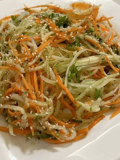A plate of my fresh and crunchy carrot and cucumber salad, lightly seasoned with sesame seeds.
