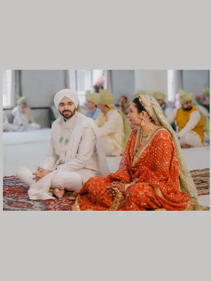 A quiet moment between the bride and groom as they sit together during their Sikh wedding ceremony.
