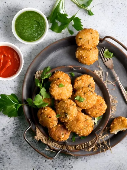 A top-down view of our crispy Sabudana Tikkis, served with traditional green and red fasting chutneys. They are perfectly fried to be crunchy on the outside and soft on the inside, making them an ideal vrat snack.