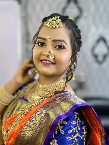 The final bridal look, combining bold makeup with an intricate hairstyle, perfect for a Maharashtrian wedding.