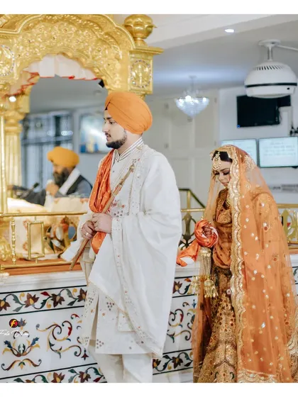 A solemn moment from an Anand Karaj ceremony inside a Gurudwara, showing the couple's reverence and the spiritual significance of the occasion.