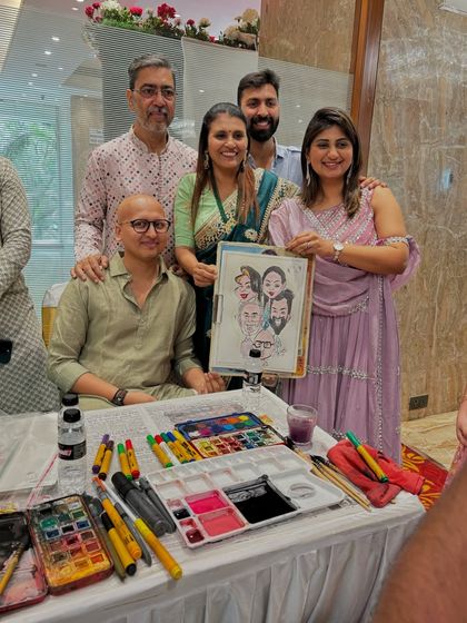 A group of happy guests posing with me at my drawing station, showing the complete setup with my art supplies.