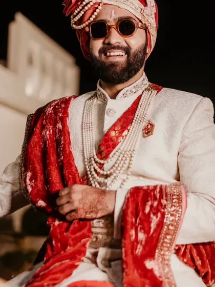 The groom on his horse, smiling and ready for his baraat. This is a classic, joyful shot of the Indian groom.