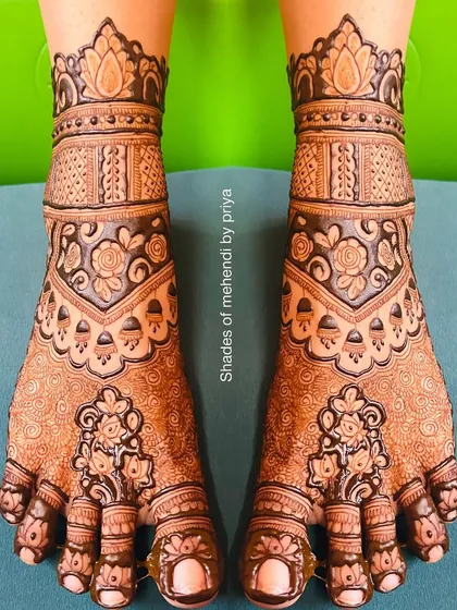 A beautifully stained, full-coverage foot mehendi with traditional floral and geometric patterns.