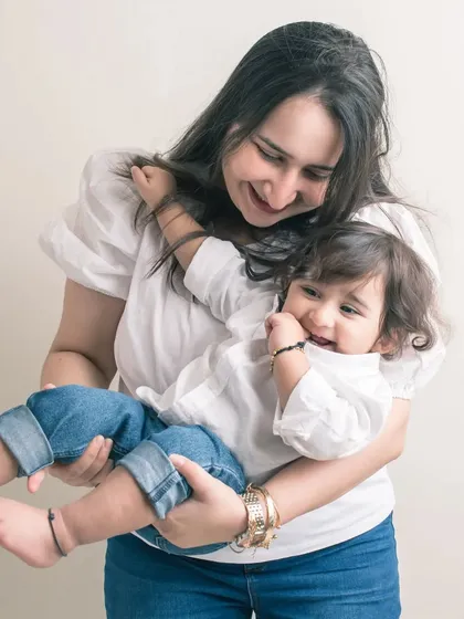 A playful moment between mother and son. Her joy is reflected in his own happy expression.