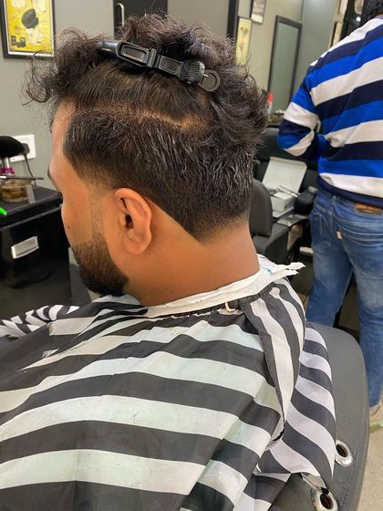 The process of creating a V-shaped taper on a client with thick, wavy hair, sectioning the hair to ensure a precise cut.