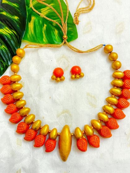 A warm orange and gold version of the leaf-textured choker.