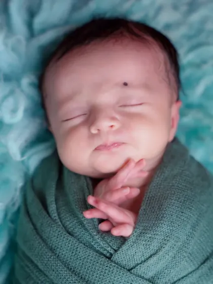 A close-up on the tiny, delicate features of a sleeping newborn. These are the details parents will want to remember forever.