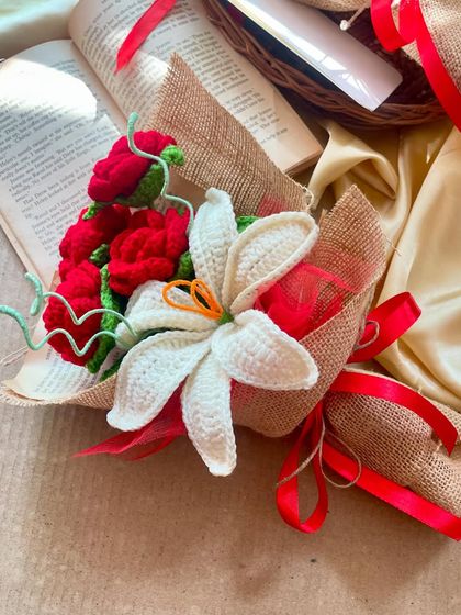 Another angle of the anniversary bouquet, styled with an open book. The combination of red roses and a white lily is a timeless classic.