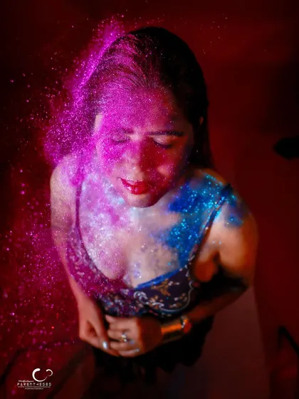 A high-angle shot of glitter raining down. This portrait is expressive and full of a joyful, celebratory energy.