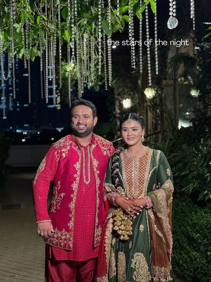 The stars of the night. The couple poses under a canopy of hanging crystals, their outfits perfectly complementing the rich, festive decor of their Mehendi celebration.