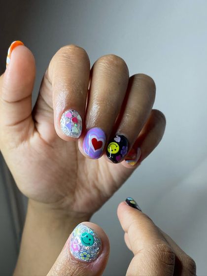 A fun and eclectic mix-and-match design with glitter, a heart, a smiley face, and floral patterns for a playful vibe.