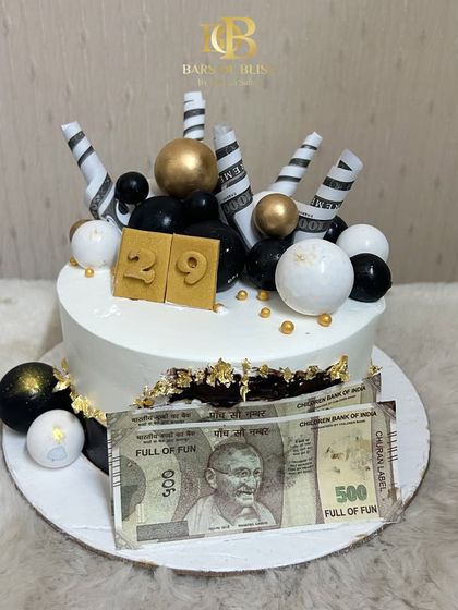 This cake is all about celebrating success and fun. It's decorated with edible currency notes, black and gold spheres, and a custom age topper, making it a great choice for a man's birthday.