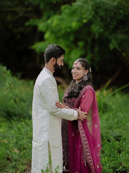A warm embrace in a forest setting. The deep greens of the background make the couple the clear focus of the image.
