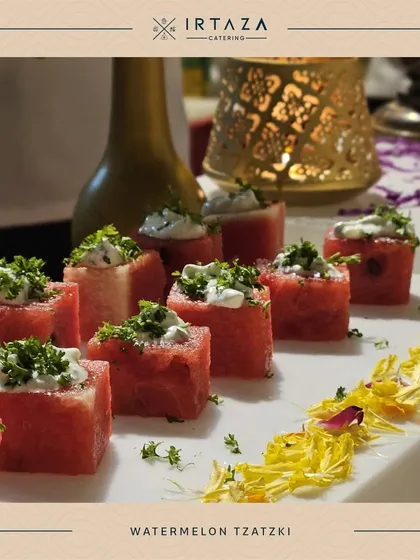 A refreshing and healthy appetizer of Watermelon Tzatziki. Cubes of fresh watermelon are topped with a creamy yogurt-based sauce and herbs, perfect for a summer event.