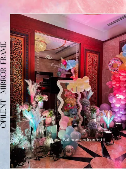 An opulent mirror frame and floral arrangements added a touch of elegance to the whimsical Candyland entrance decor.