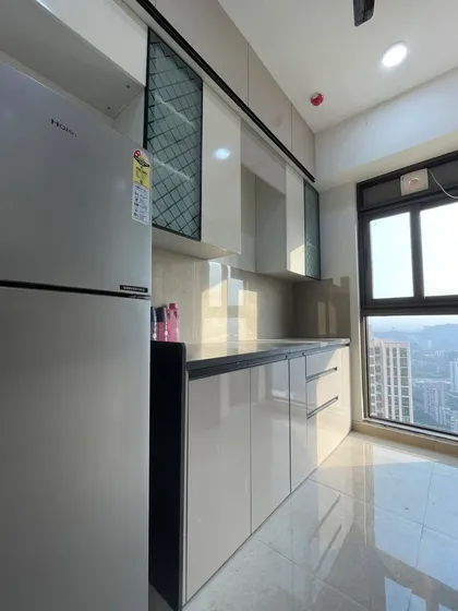 The glossy, light-colored cabinets reflect light, making this compact kitchen feel bright and spacious.
