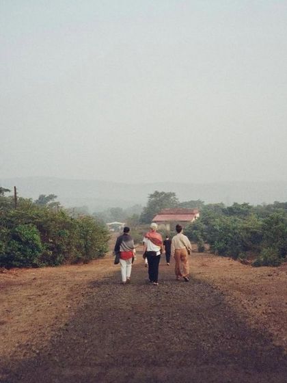 Students and teachers walking along the simple path towards the ashram in Amboli. The journey here is both physical and spiritual, leading to a place of profound learning.