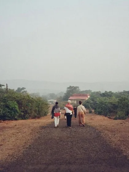 Students and teachers walking along the simple path towards the ashram in Amboli. The journey here is both physical and spiritual, leading to a place of profound learning.