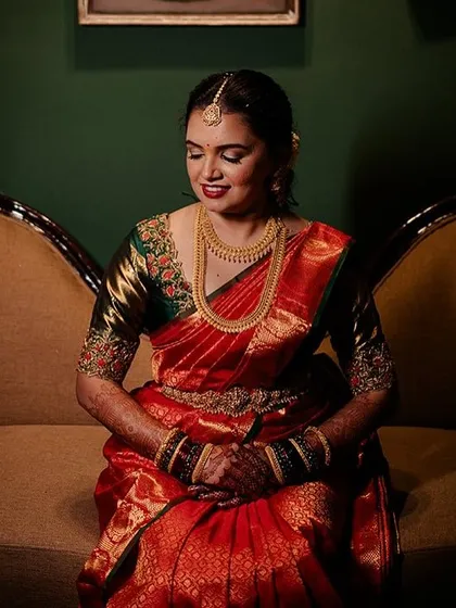 A bride seated on a vintage sofa, the low lighting creating a moody and intimate portrait.