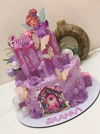 A different angle of the lavender Barbie fairy cake, showing the drip effect and bubble decorations.