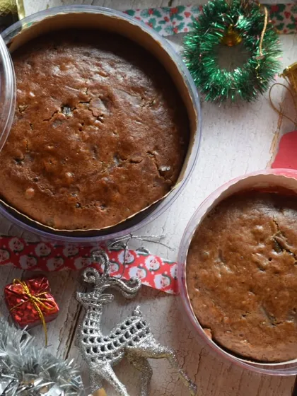 More of my Christmas cakes, ready to be delivered. The festive packaging with red doilies and ribbons adds to the holiday spirit.