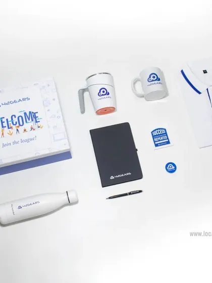 This welcome kit for 42Gears includes a branded polo t-shirt, a water bottle, a spill-proof suction mug, a classic ceramic mug, a notebook and pen, and custom badges, all presented in a "Welcome to the League" box.