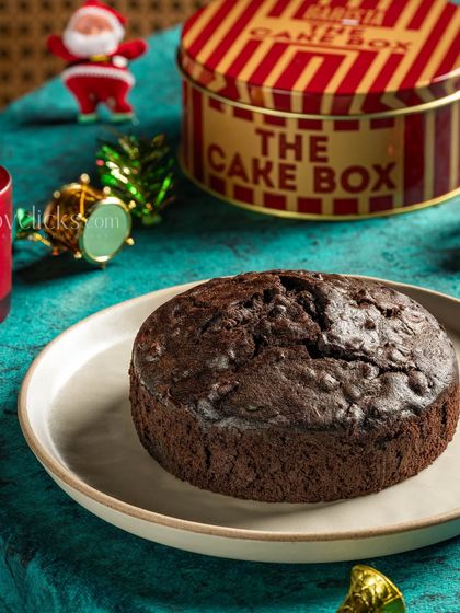 A close-up of a Christmas plum cake, with a focus on its rich, dark texture, set against a festive backdrop.