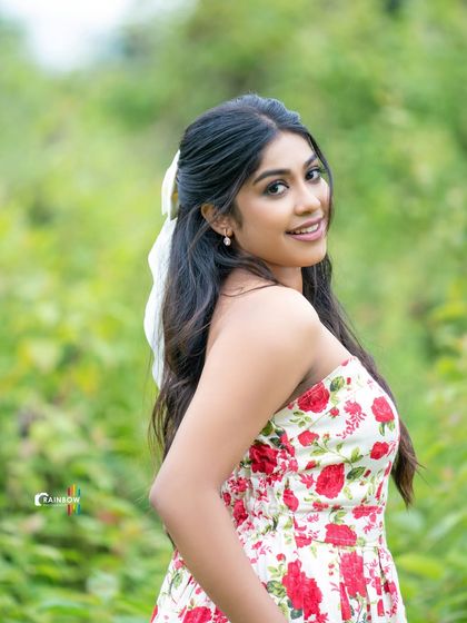 A back view of a model in a floral dress, showing off her hairstyle and the playful bow.