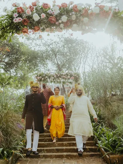 The bride's grand entrance, walking down the steps under a floral arch, escorted by her brothers. A key moment in any Maharashtrian wedding ceremony.