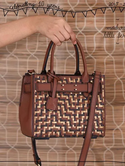 The Little Perry satchel in our signature Madurai weave. The tri-color woven panel on the front adds a beautiful, artisanal touch to this structured and classic bag shape, making it a standout piece.