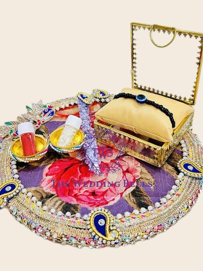 Our Rakhi trays come in different themes and colors. This one has a vibrant floral purple fabric base with peacock paisley motifs.