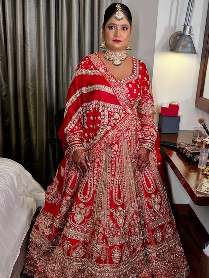A full-length view of this stunning bride in her red lehenga. The makeup was kept classic and radiant to let her natural beauty and the magnificent outfit shine.