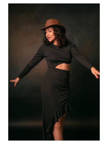 A playful and energetic portrait of a model dancing in a cowboy hat. The image captures a moment of pure joy and freedom.