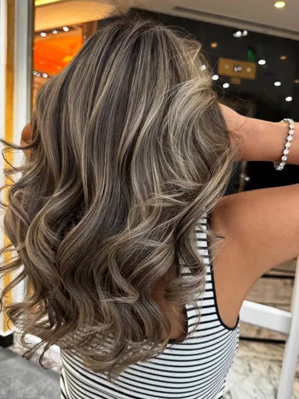 An ash blond hair balayage with beautiful, cool-toned highlights and soft waves.